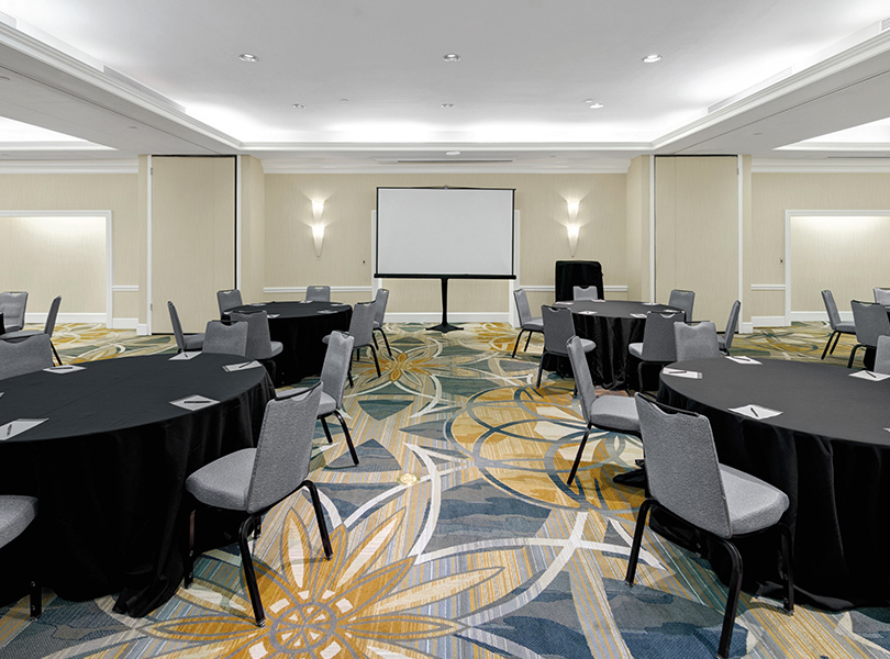 Junior Ballroom Crescent room with tables and chairs all neatly lined up with a presenter board in the middle