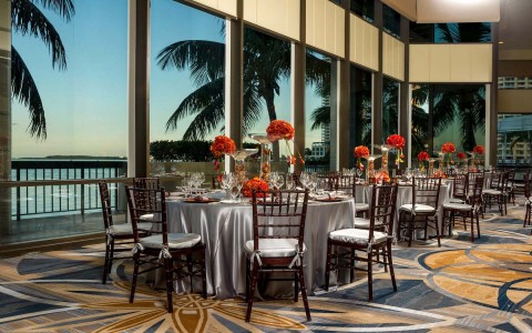 ballroom with windows and round tables with chairs