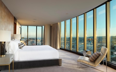 large bedroom with a view of the city