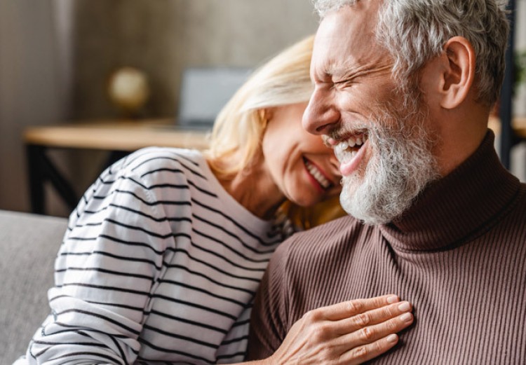 Elderly couple embracing each other while smiling
