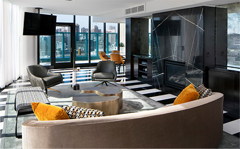 interior of a suite living room area with black and white tile floors and modern couches