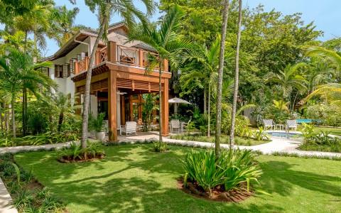 Tropical trees and villa with the sun shining.