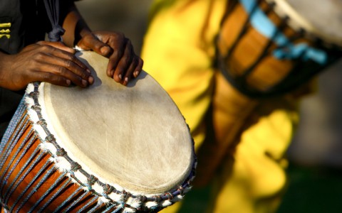 A person playing the hand drums.