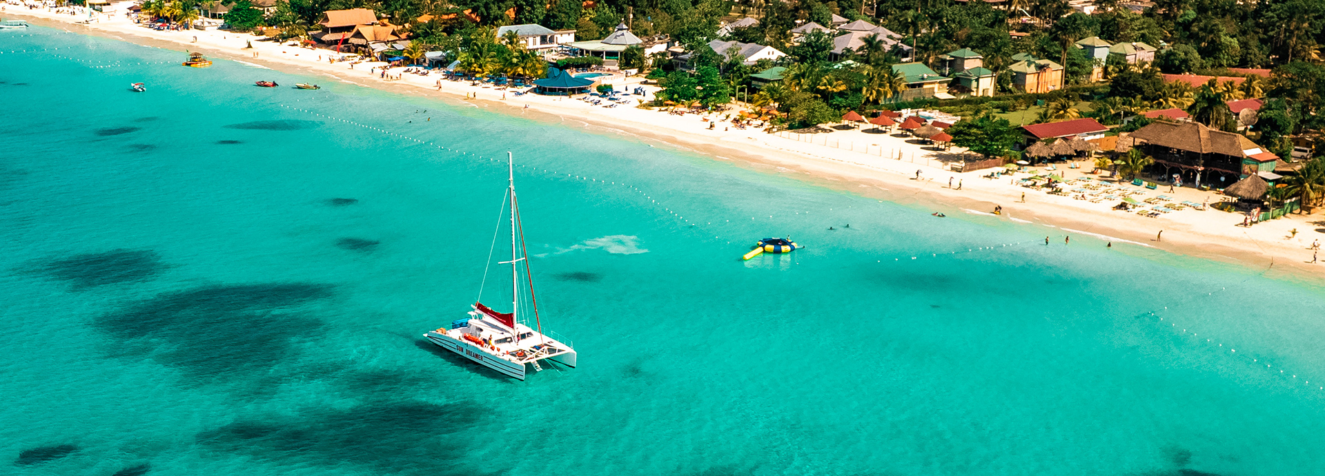 Large catamaran in bright blue water.