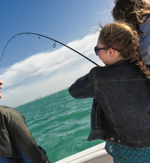 man fishing on a boat with two little girls