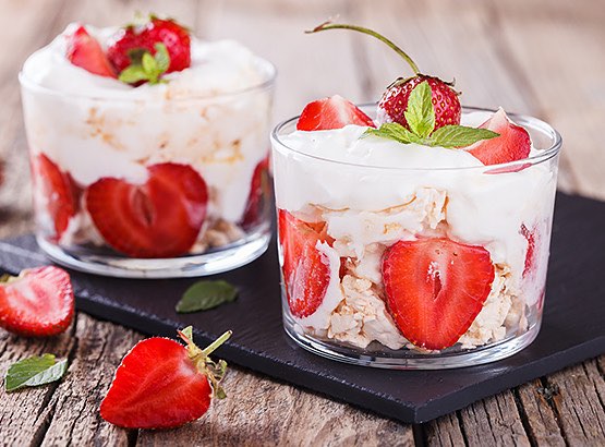 Cups with greek yogurt, oatmeal & sliced strawberries