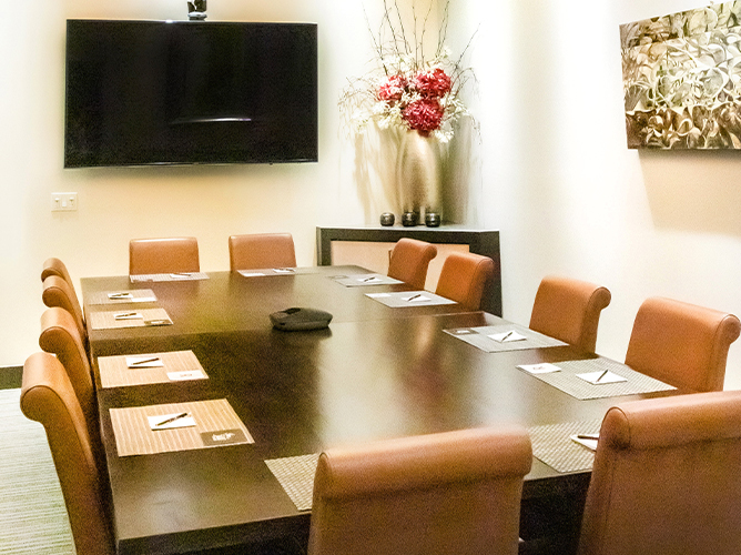 boardroom with table for 12 people and a tv