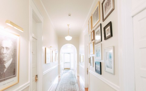 White hallway in hotel with frames hung