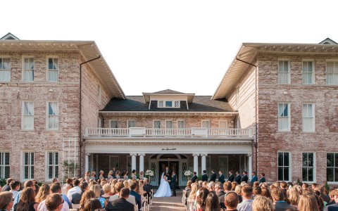 large outdoor wedding on the steps of the front of the hotel
