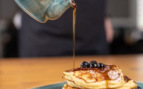 chef pouring syrup on pancakes