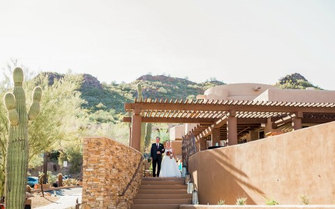 bride and groom standing on top of outdoor stairs