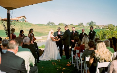 couple getting married with a view of the gold course in the background 