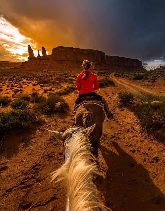 person horse back riding with the mountains in the background