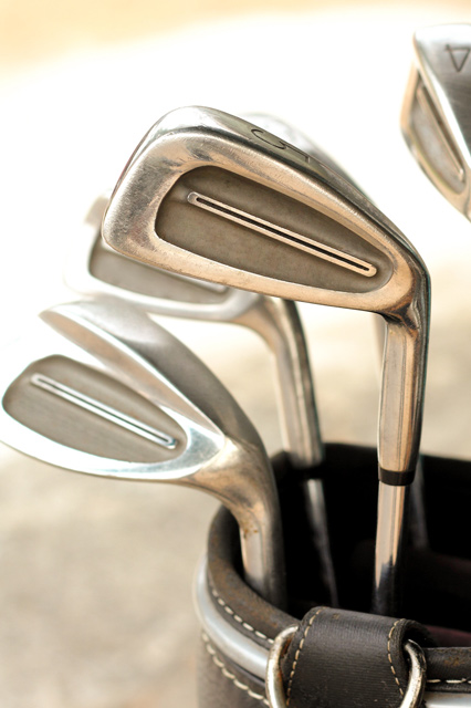 closeup f gold clubs in bag