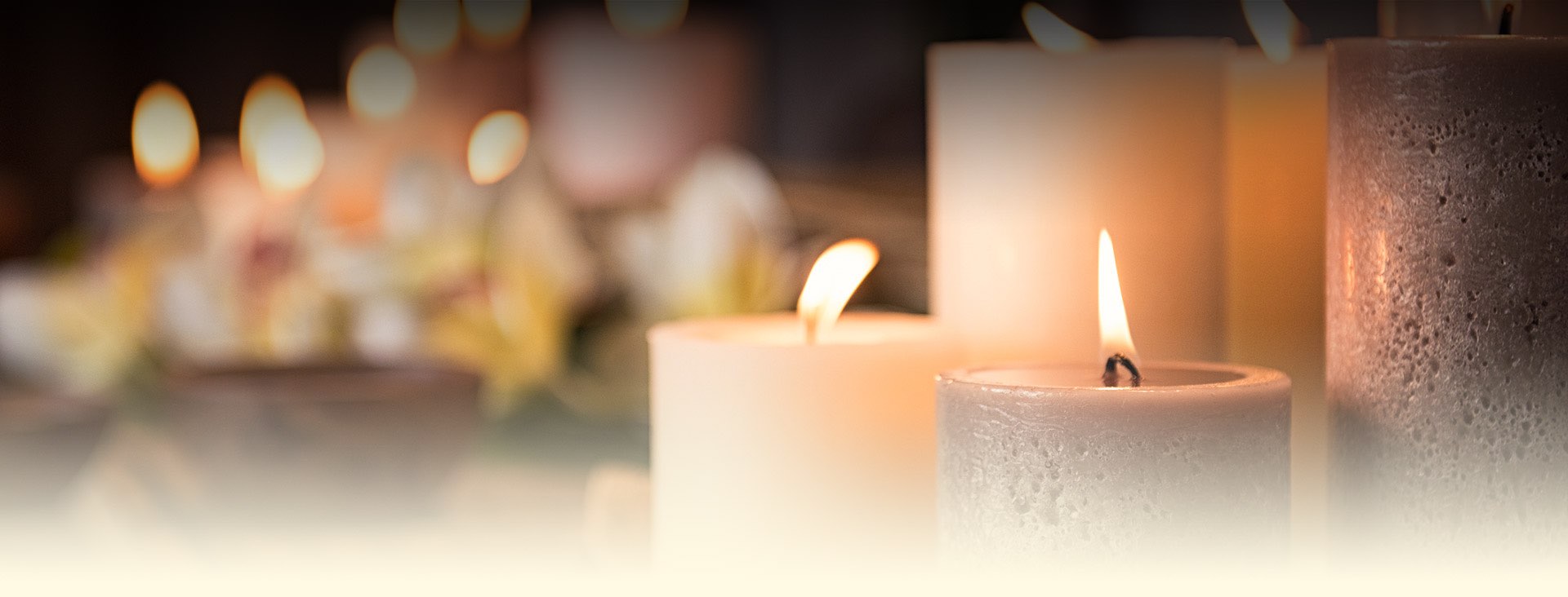closeup of white and tan lit candles