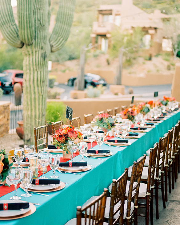 long table ready for a wedding reception next to tall cactus