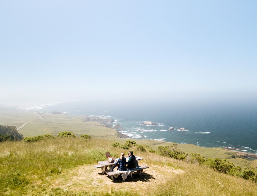 cliff with couple sitting at picnic table