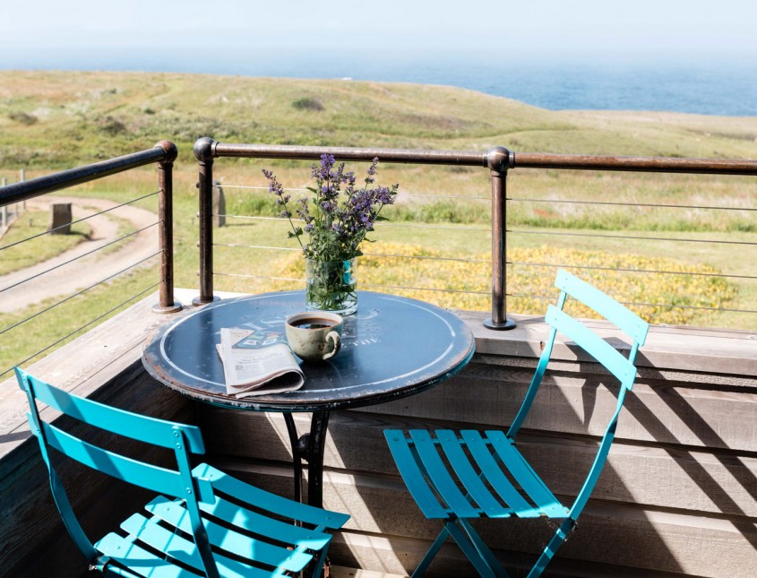 blue patio chairs and table on a patio overlooking lawn