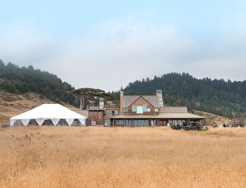 a view of the main inn building and a large white event tent