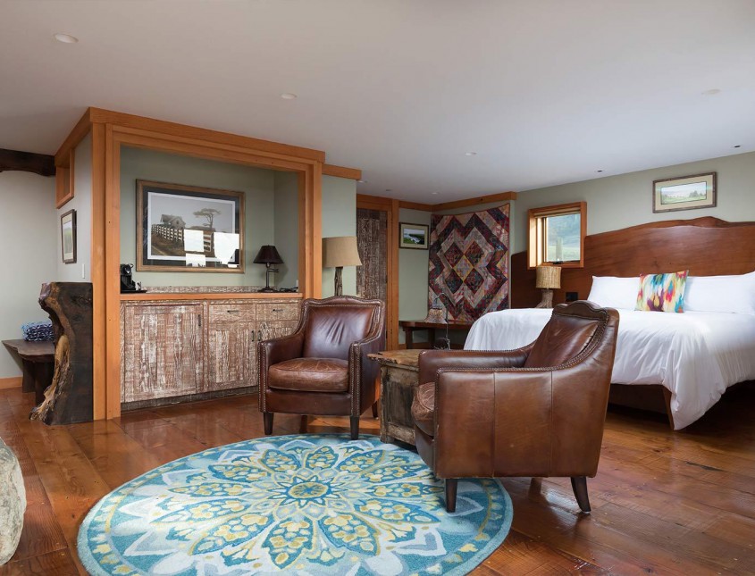 hearhtstone suite with bed, leather chairs, blue carpet, and wood floors