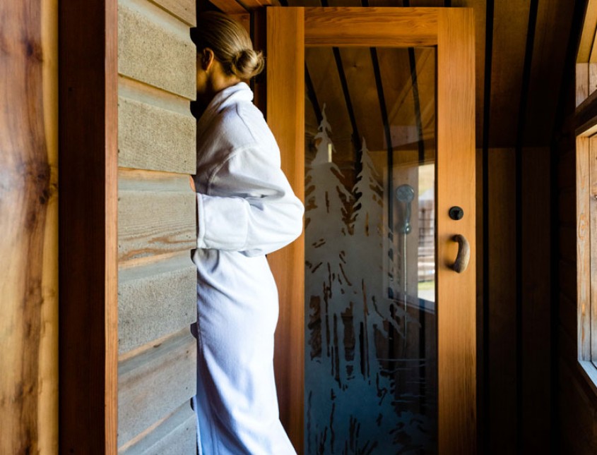 woman in a white bath robe walking into a door