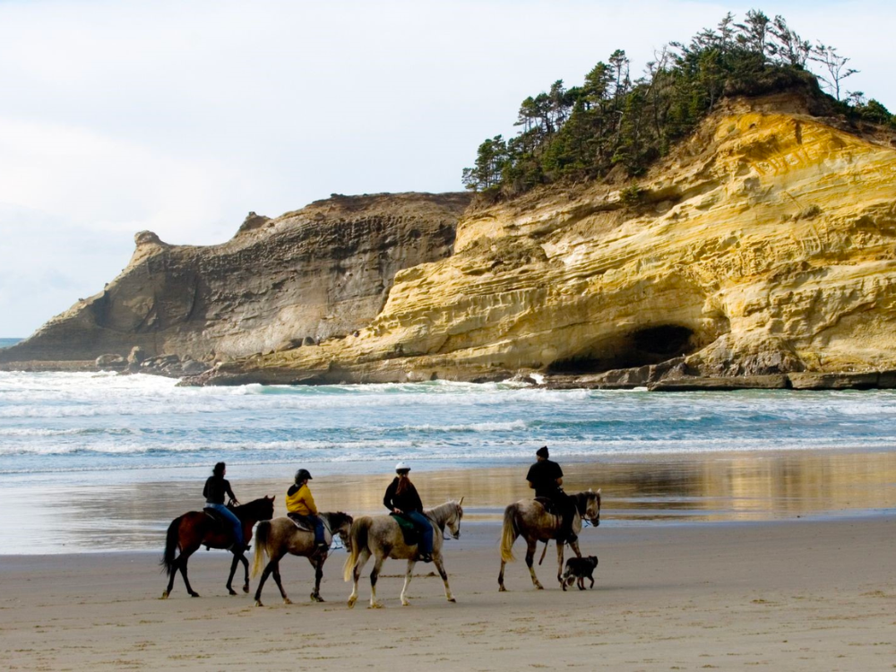 family horseback riding on the beach