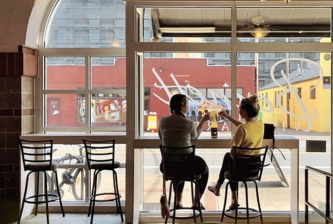 two people cheersing in a cafe