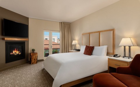 hotel room with chimney, tv, individual sofa, lamps and window 