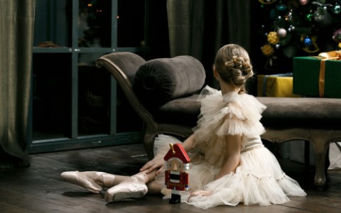 young ballerina in tutu with nutcracker toy