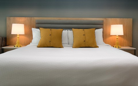 a king bed with orange pillows