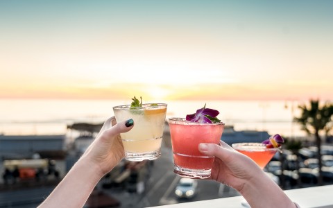 a couple drinking cocktails on the beach