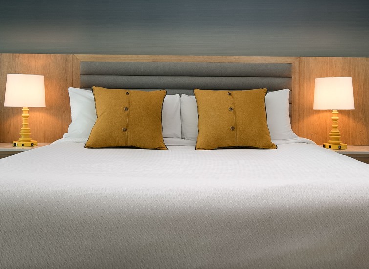 a king bed with four orange pillows