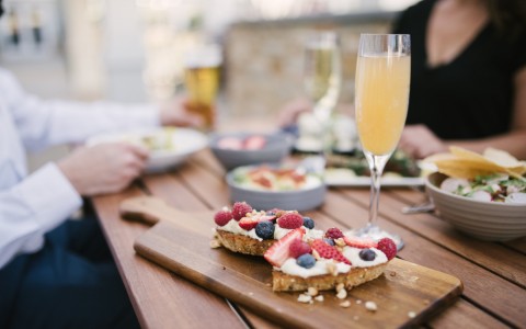 brunch toast with fruit toppings and mimosa on table 