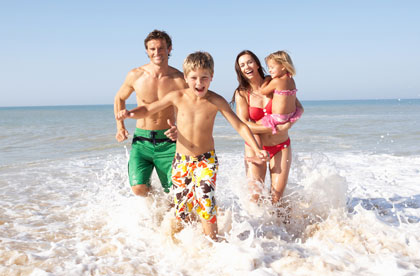 Playful family of four splashing in the ocean
