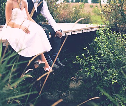 Bride and groom sitting on dock