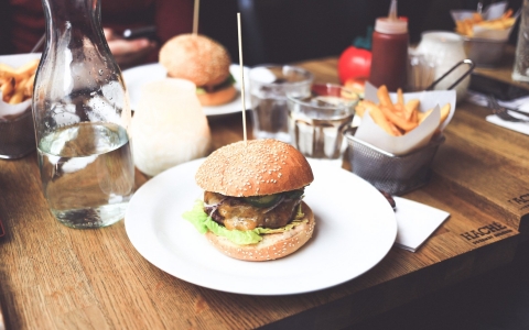 Burger dishes and side of fries with glasses of water