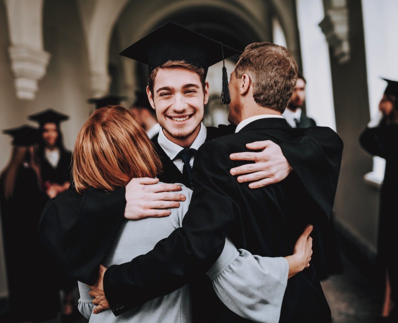 parents hugging their son who just graduated