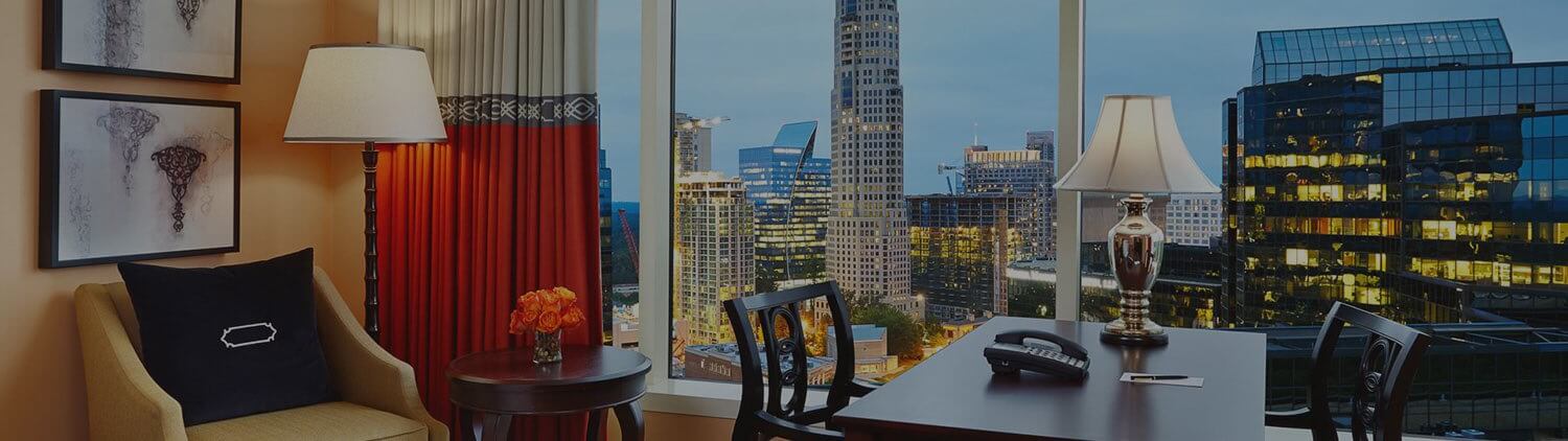 hotel suite with large windows showing the Atlanta skyline at dusk