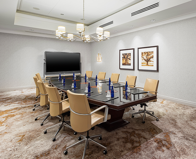 Willard meeting room with a large flat screen tv and light brown chairs
