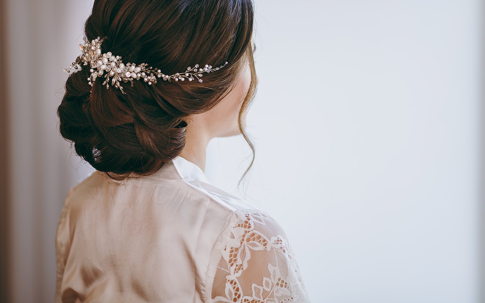 view of bride from behind the shoulder with hair in braids and curl down side of face