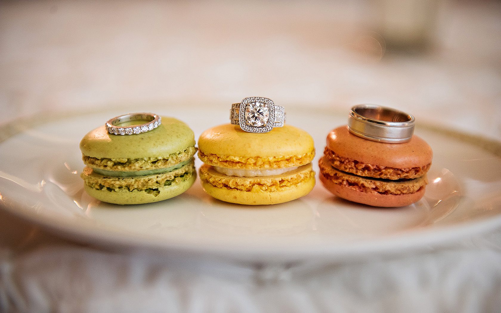 green, yellow, and brown macaron cookies with rings sitting atop them