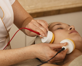 women giving a spa facial treatment