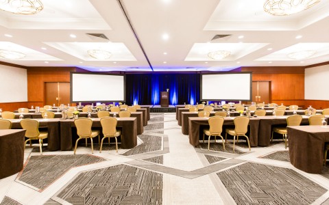 large meeting space with many seats and two projectors