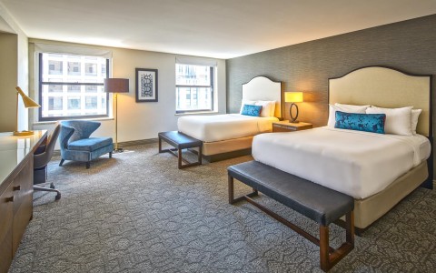 two large beds in a big room with a view of the city