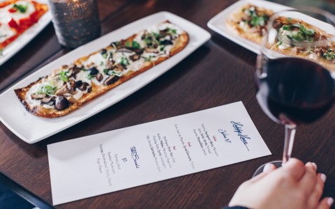 guest enjoying flatbreads and wine