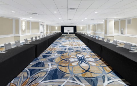 U-Shape meeting room space. Modern decor and carpet, long tables facing each other with gray chairs