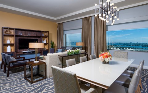 Miami Room Suite Executive Suite Table with gray chairs in the living room 