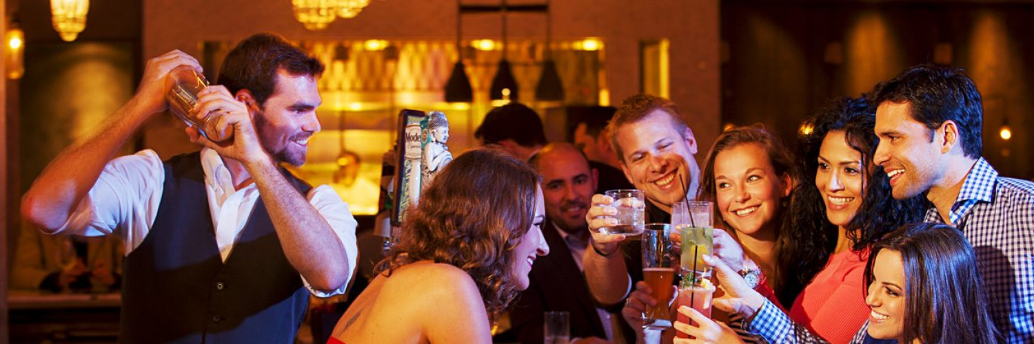 friends surrounding a bartender making drinks