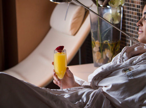 a woman relaxing at the spa in an intercontinental robe, holding a glass of orange juice