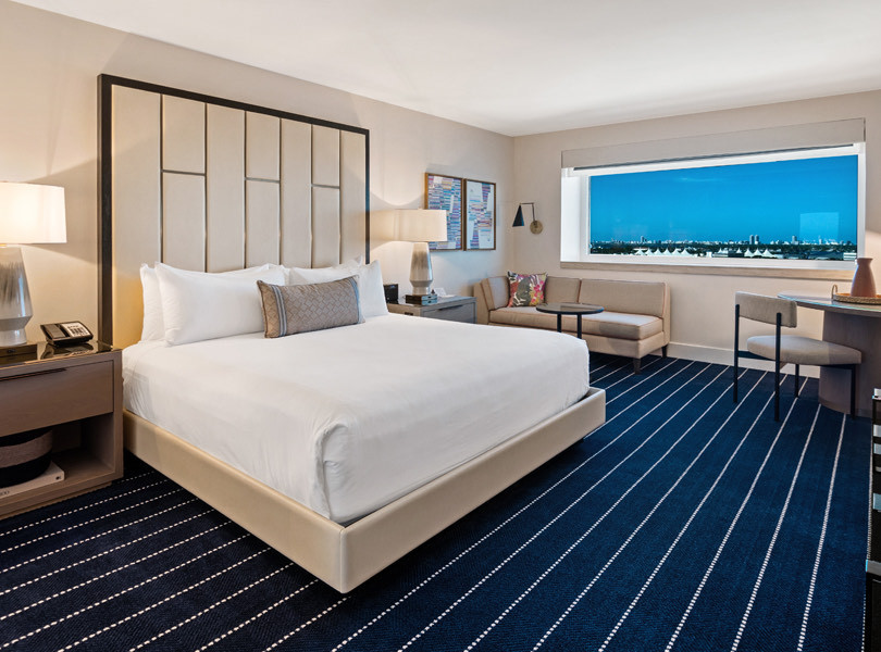 blue and white striped carpet with a large white bed on top